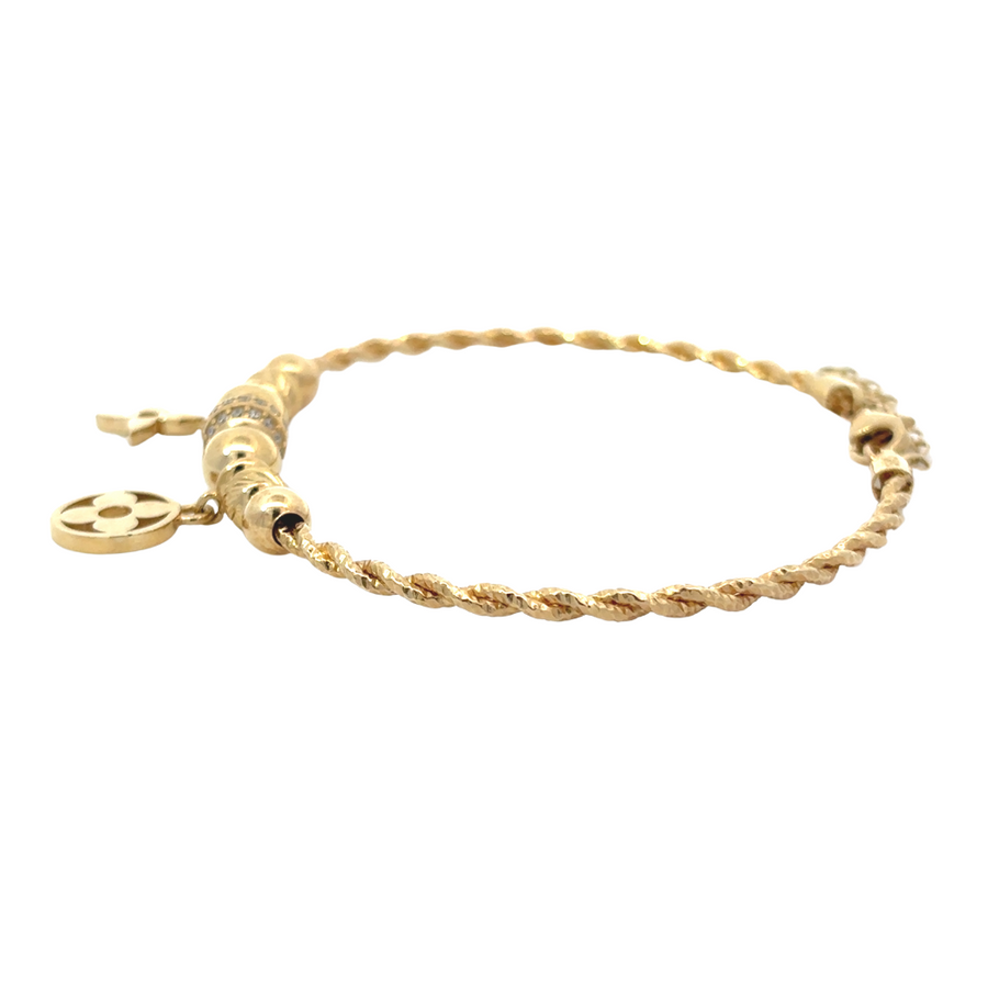 Woman wearing the 14k gold bracelet, demonstrating its subtle elegance paired with a casual outfit