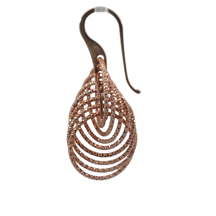 Close-up of silver earrings with elegant rose gold finish