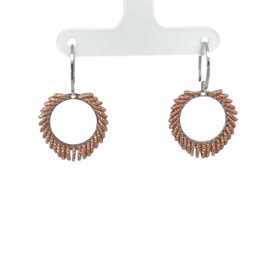 Close-up of delicate silver drop earrings on white background