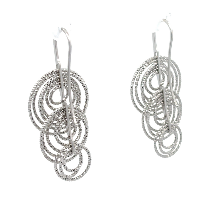 Side view of polished diamond-cut silver earrings showing reflective facets