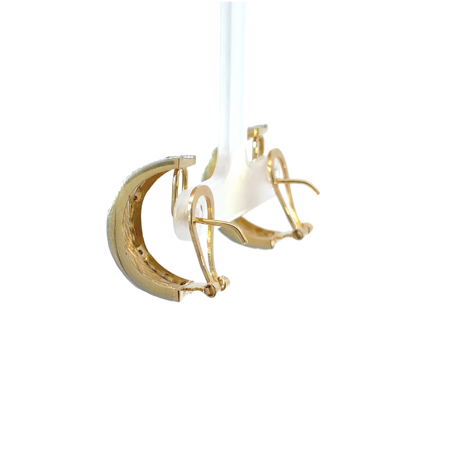 Close-up of 18k yellow and white gold earrings featuring diamond accents