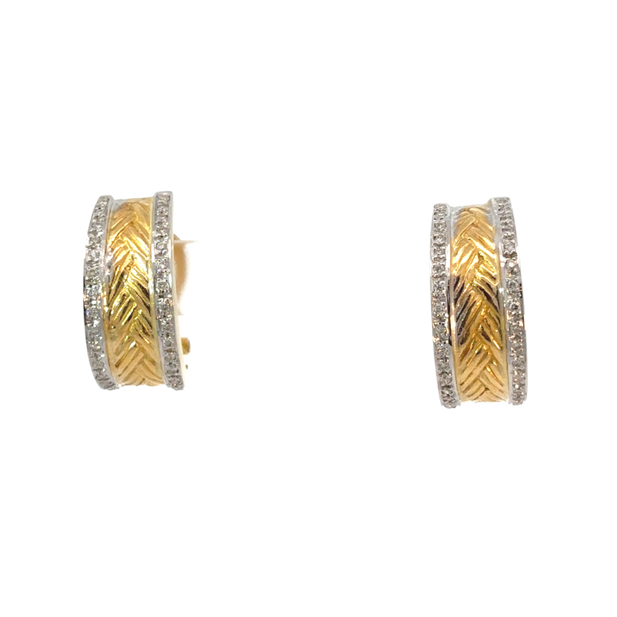 Pair of two-tone earrings with diamonds on white marble background