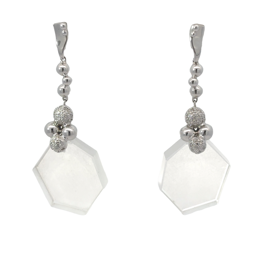 Pair of white gold earrings with diamonds on soft ivory fabric