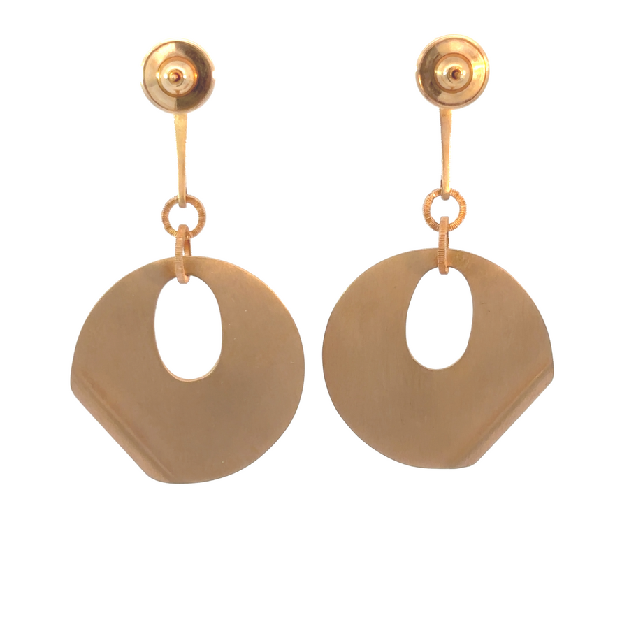 Woman wearing 18k gold earrings with shimmering diamonds