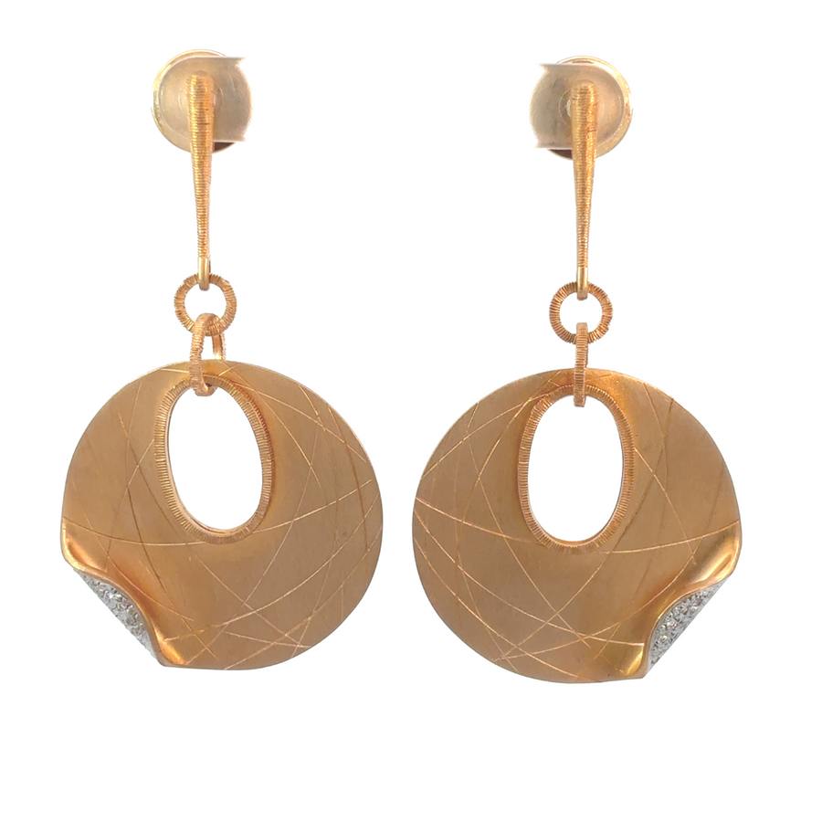 Close-up of women’s 18k gold earrings with sparkling diamonds