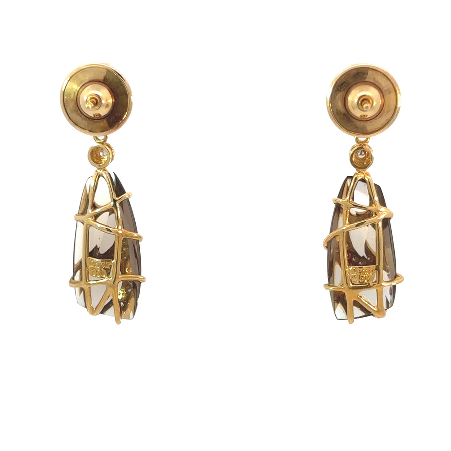 Woman wearing yellow gold earrings featuring smoky quartz and diamonds