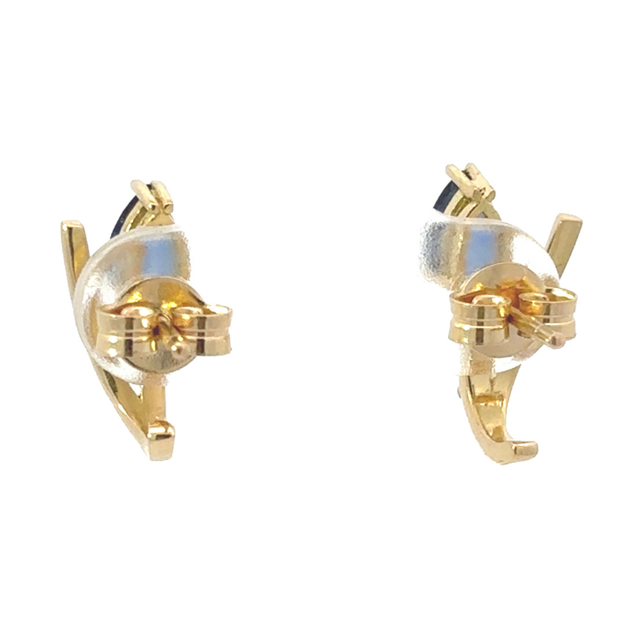 Close-up of sapphire stud earrings in yellow gold